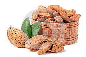 Heap of almonds in their skins and peeled with leaf isolated on white background