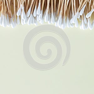 Heap of bamboo cotton swabs or buds top view on beige background