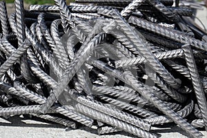 A heap of bent division rebar - curved steel reinforcement bars at a construction site