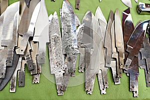 Heap billets of forged steel for knives on green photo