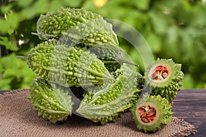 Heap of bitter melon or momordica on wooden table with blurred background