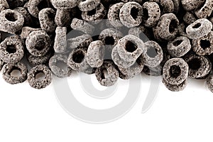 Heap of black cereal rings isolated on white background, delicious and useful rings breakfast cereal, view close-up