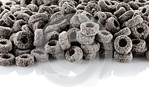 Heap of black cereal rings isolated on white background, delicious and useful rings breakfast cereal, view close-up