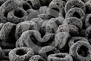 Heap of black cereal rings isolated on white background, delicious and useful rings breakfast cereal, view close-up