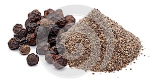 Heap of black peppercorn and powder