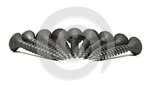 Heap of black steel screws arranged in a radial pattern