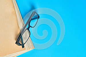 Heap of blank magazines, newspapers or some documents and modern glasses on blue desk