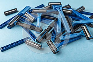 Plastic razors heap on blue background