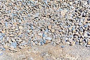 Heap of blue-gray and brown rubble from roughly crushed hard or dense quarry rock