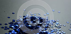 The heap of a bright blue glitter confetti stars. Holiday background. Christmas decoration