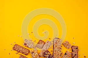 Heap of broken granola bars on yellow background