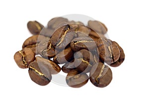 Heap of brown coffee beans isolated on white background