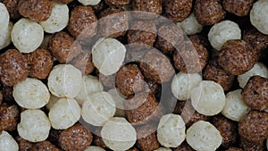 Heap of brown and white chocolate cereal balls on rotating surface - close up