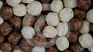 Heap of brown and white chocolate cereal balls on rotating surface - close up