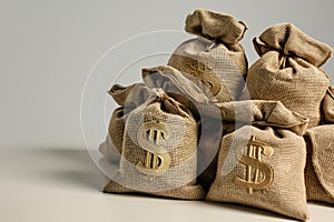 Heap of burlap bags with a gold symbol USD on them, on solid studio background