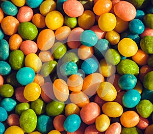 Heap of candy confections small many green, yellow, blue colors. Bright texture and round forms of sweets in sugar