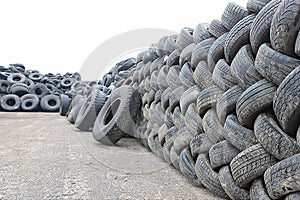 A heap of car tires on the asphalt. Tire Manufacturing Plant