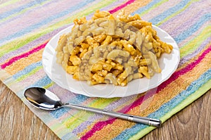 Chuck-chuck in plate, teaspoon on napkin on wooden table photo