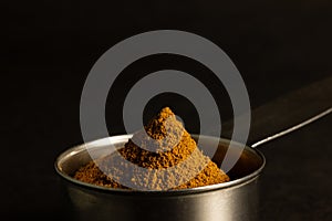 Heap of Cinnamon In Measuring Cup