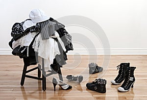 Heap of clothing on a stool and disordered shoes