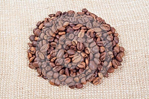 Heap of coffee beans on background of burlap