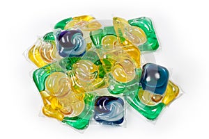 Heap of colored laundry detergent capsules on a white background