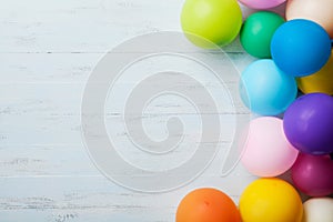 Heap of colorful balloons on blue wooden table top view. Birthday or party background. Flat lay style. Copy space for text.