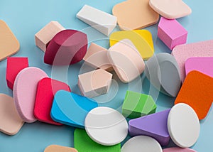 The Heap of colorful cosmetic sponges on blue background. Top view