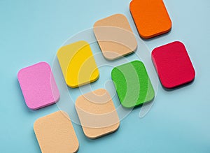 The Heap of colorful cosmetic sponges on blue background. Top view