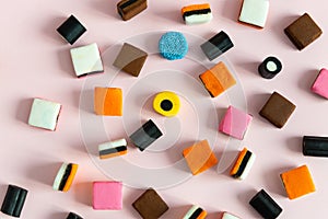 Heap of colorful Liquorice allsorts on pink background. Sweets