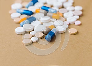 Heap of colorful pills, pharmaceutical medicine tablets and capsules on beige yellow background. Drug prescription for treatment
