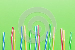 Heap of colorful plastic drinking straws on Colored background, flat lay. Copy Space for text