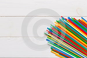 Heap of colorful plastic drinking straws on Colored background, flat lay. Copy Space for text