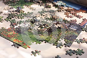 Heap of colorful Puzzles elements on beige surface