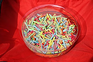 Heap of colorful tombola tickets are lying in a plastic bowl