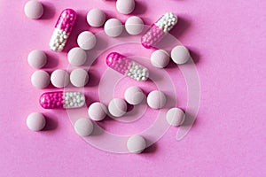 Heap of colorfull pills, tablets, capsules on pink background. Drug prescription for treatment medication health care concept wth