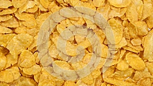 Heap of cornflakes rotating close up, cereal breakfast or food concept, top view flat lay from above