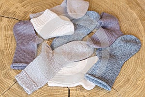 Heap of cute small different colored cashmere knitted newborn baby socks on a wooden desk background