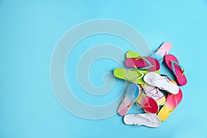 Heap of different flip flops and space for text on background, top view. Summer beach accessories