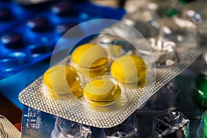 Heap of different pills in blisters pack. Close up of green, yellow, white tablets. Vitamins, painkillers, antibiotics