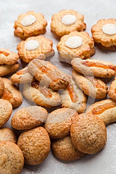 Heap of different small cookies on grey background