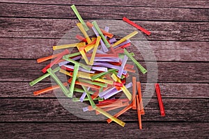 A heap of different tombola tickets with different colors are lying on a wooden Table
