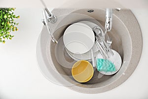 Heap of dirty dishes in kitchen sink