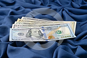 Heap of Dollar Bills on blue fabric background