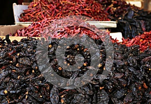 Heap of dried Ancho chile peppers on counter at market