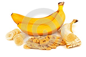 Heap of dried banana chips with banana bunch with slices