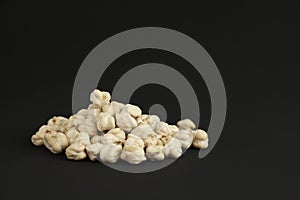 Heap of dried chickpeas on black background with copy space