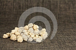 Heap of dried chickpeas on cloth, chickpea are high in vegetable protein, side view with copy space
