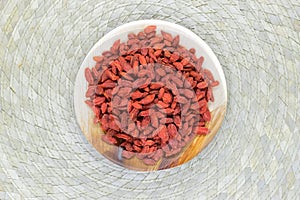 Heap of Dried Goji Berries Placed in Eco Natural Banana Leaf Plate on Bamboo Mat Background Surface with Free Space