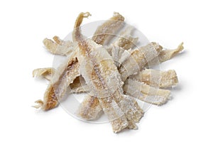 Heap of dried and salted cod close up isolated on white background